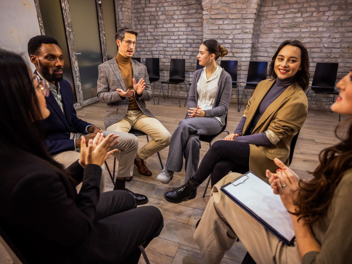 A small group of adults talking in a supportive circle